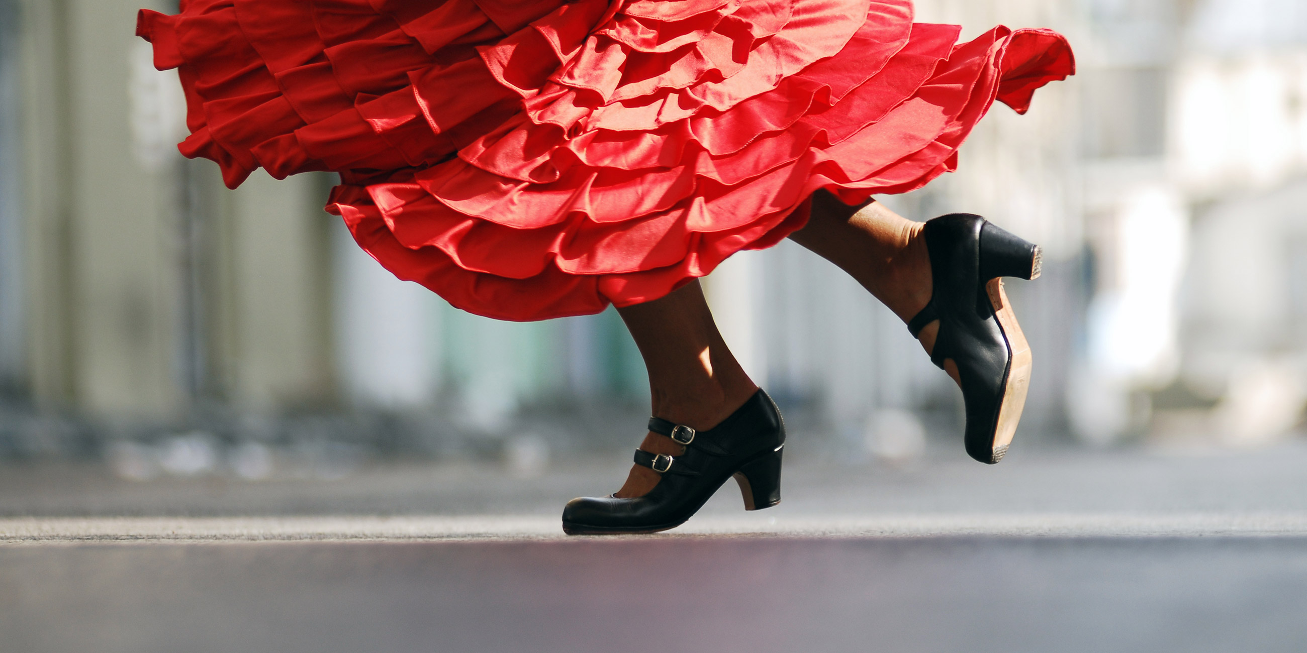 Flamenco dancer wearing black shoes and red dress