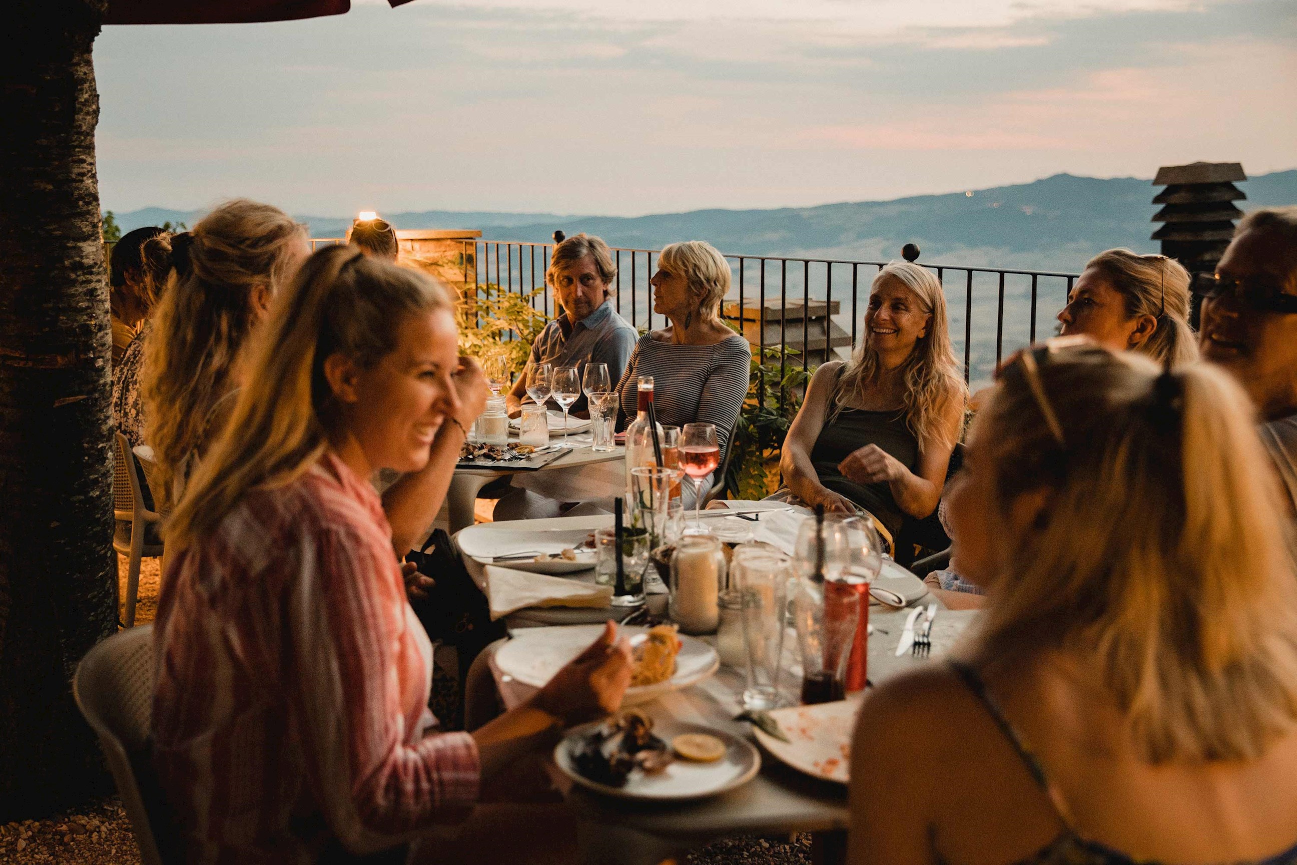 A group of tourists enjoying a dinner together in Castelmola, Italy