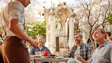 Guests talking to a waiter while in Lisbon, Portugal