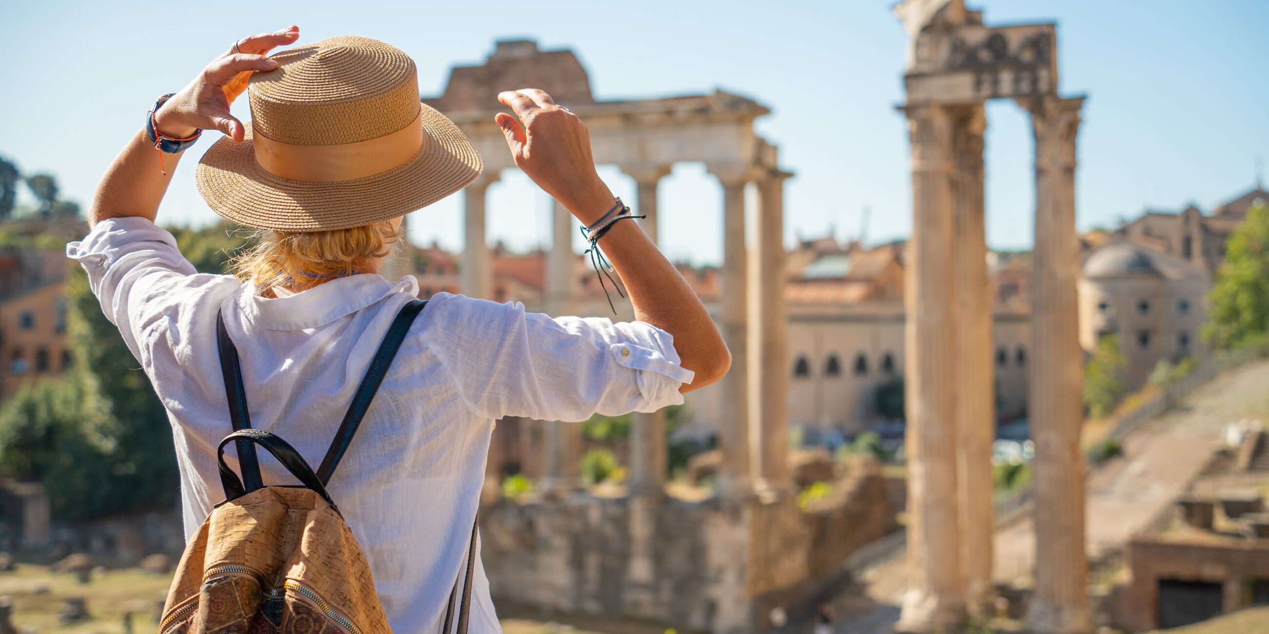 Tourist in the hat standing in front of Roman Forum, Italy
