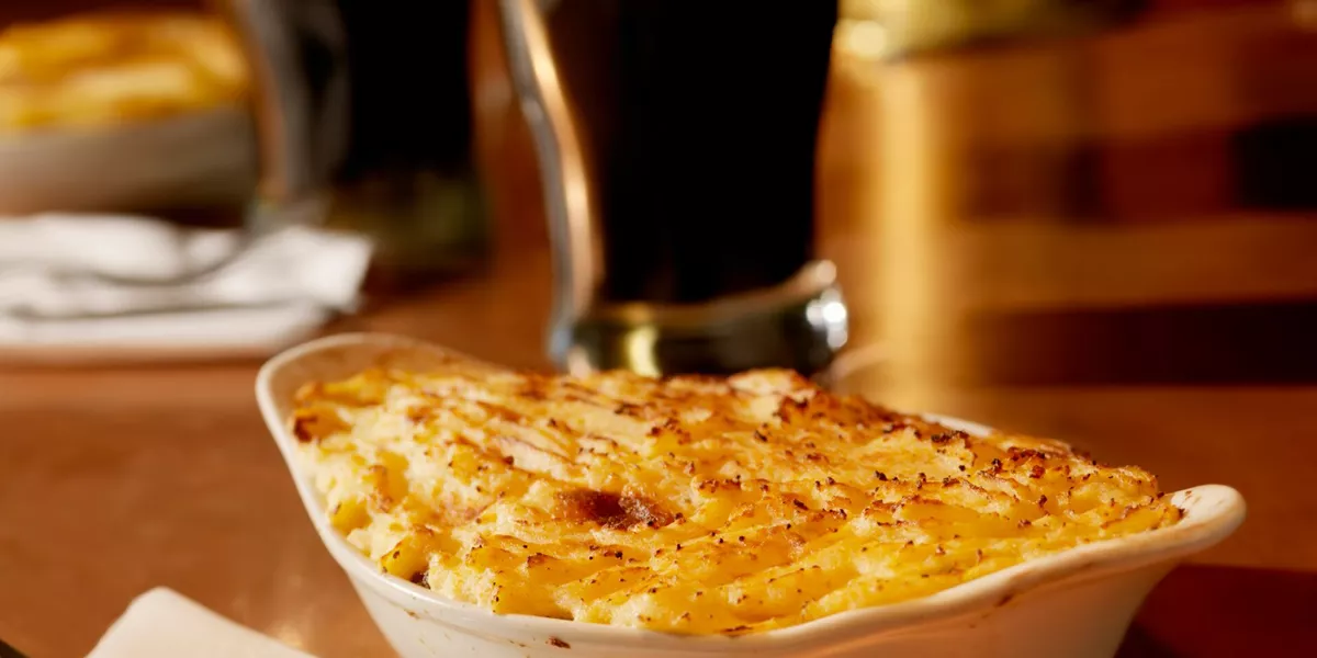 Shepherds pie with pints of stout in the background in an Irish pub in Ireland