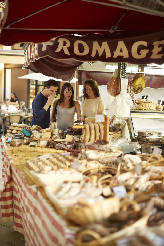 Tourists tasting cheeses at local French street market