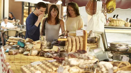 Tourists tasting cheeses at local French street market