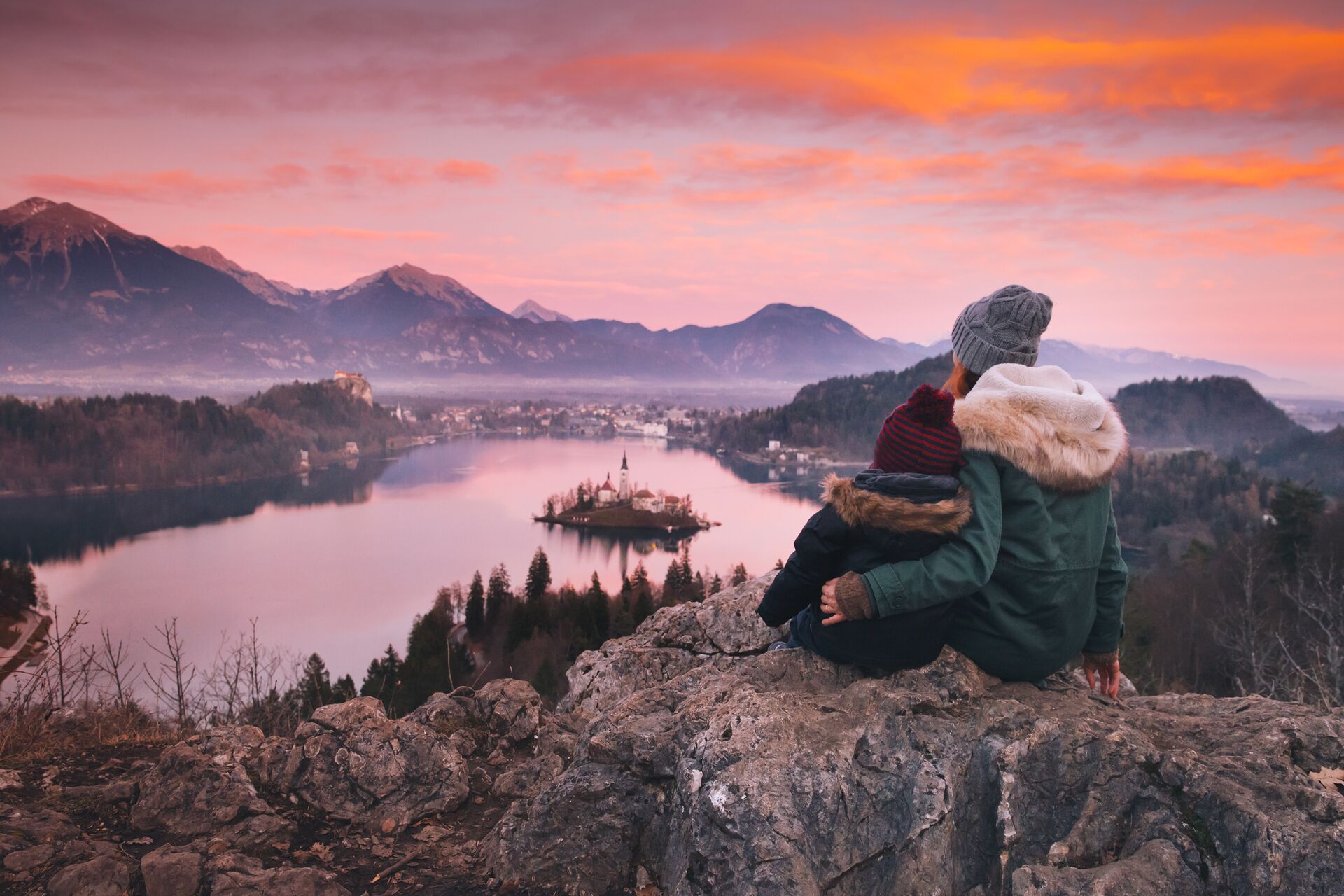 Woman and child admires Bled Lake in Slovenia during winter
