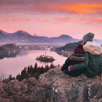 Woman and child admires Bled Lake in Slovenia during winter