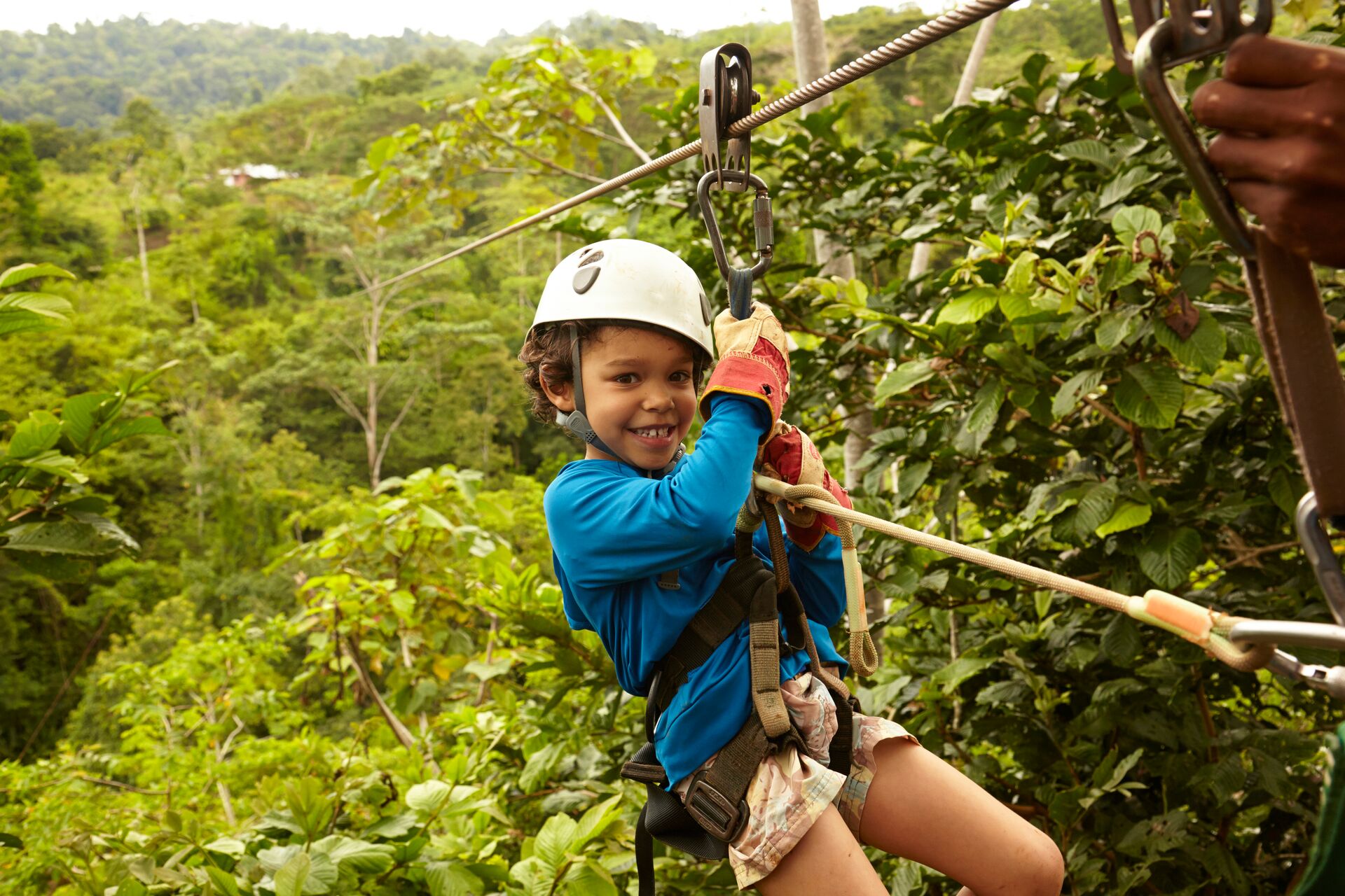 Boy zip lining through the jungle in Costa Rica, Latin America