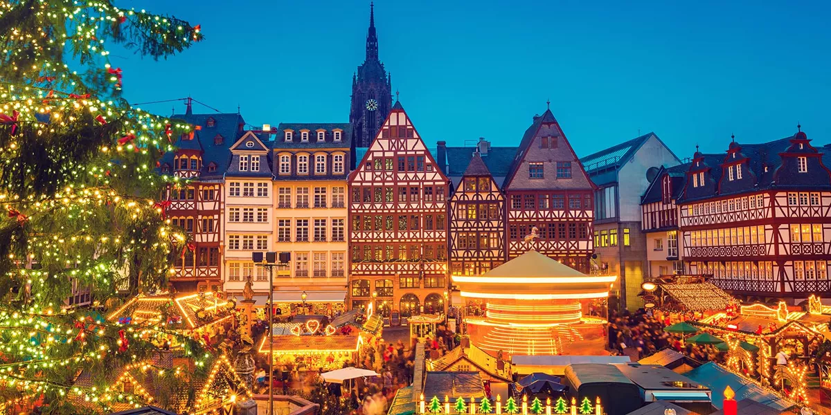A christmas tree, lights and booths at a christmas market