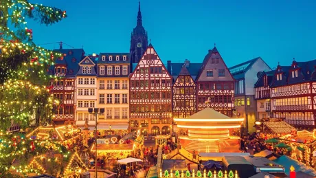 A christmas tree, lights and booths at a christmas market