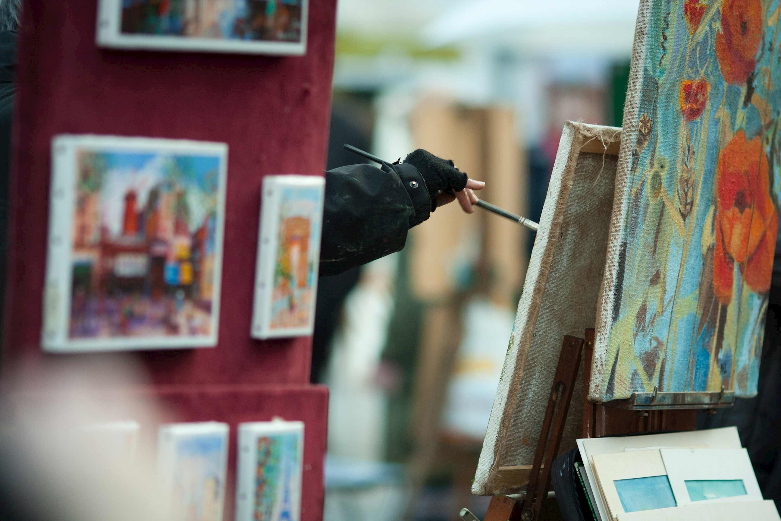 A person working on a painting in Montmartre Village in Paris, France