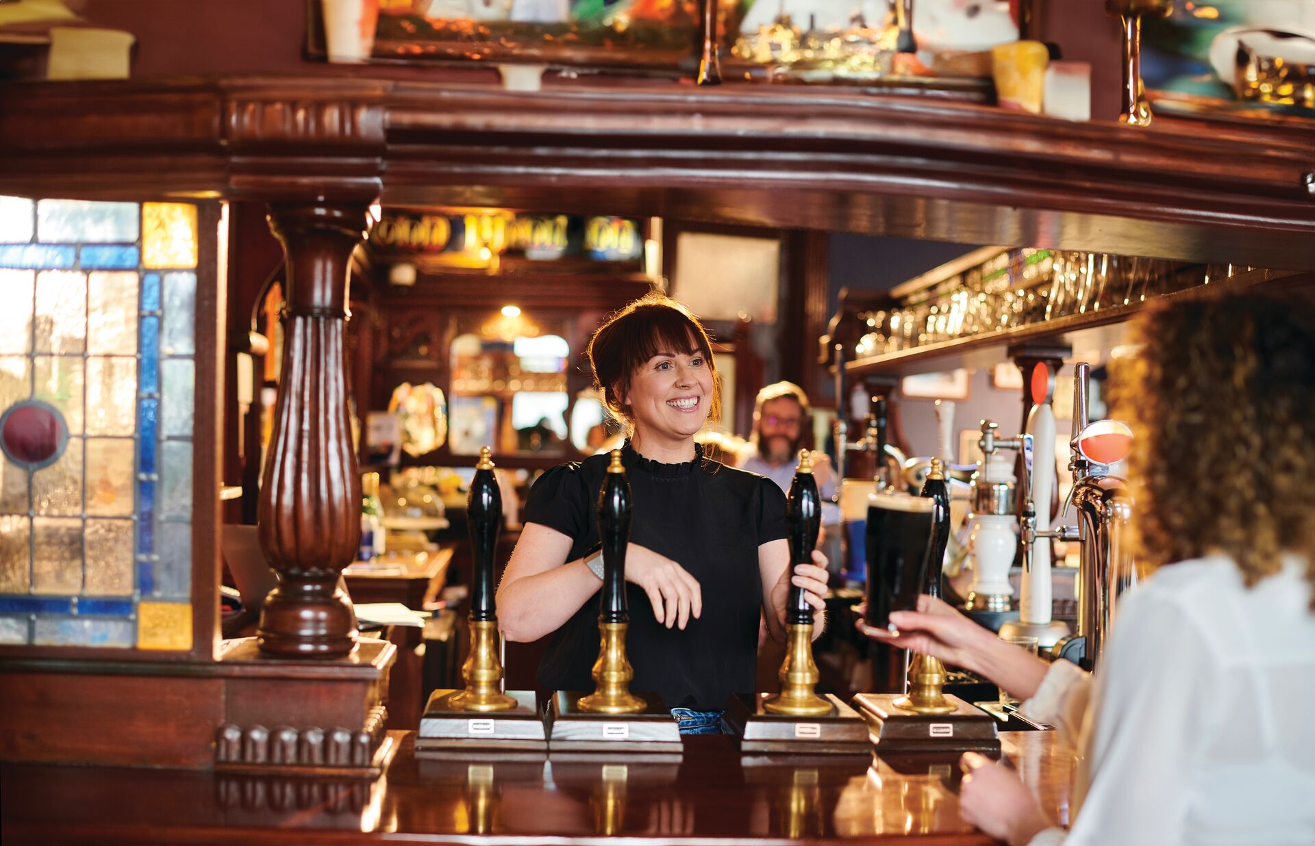 Woman greeting patrons at a pub