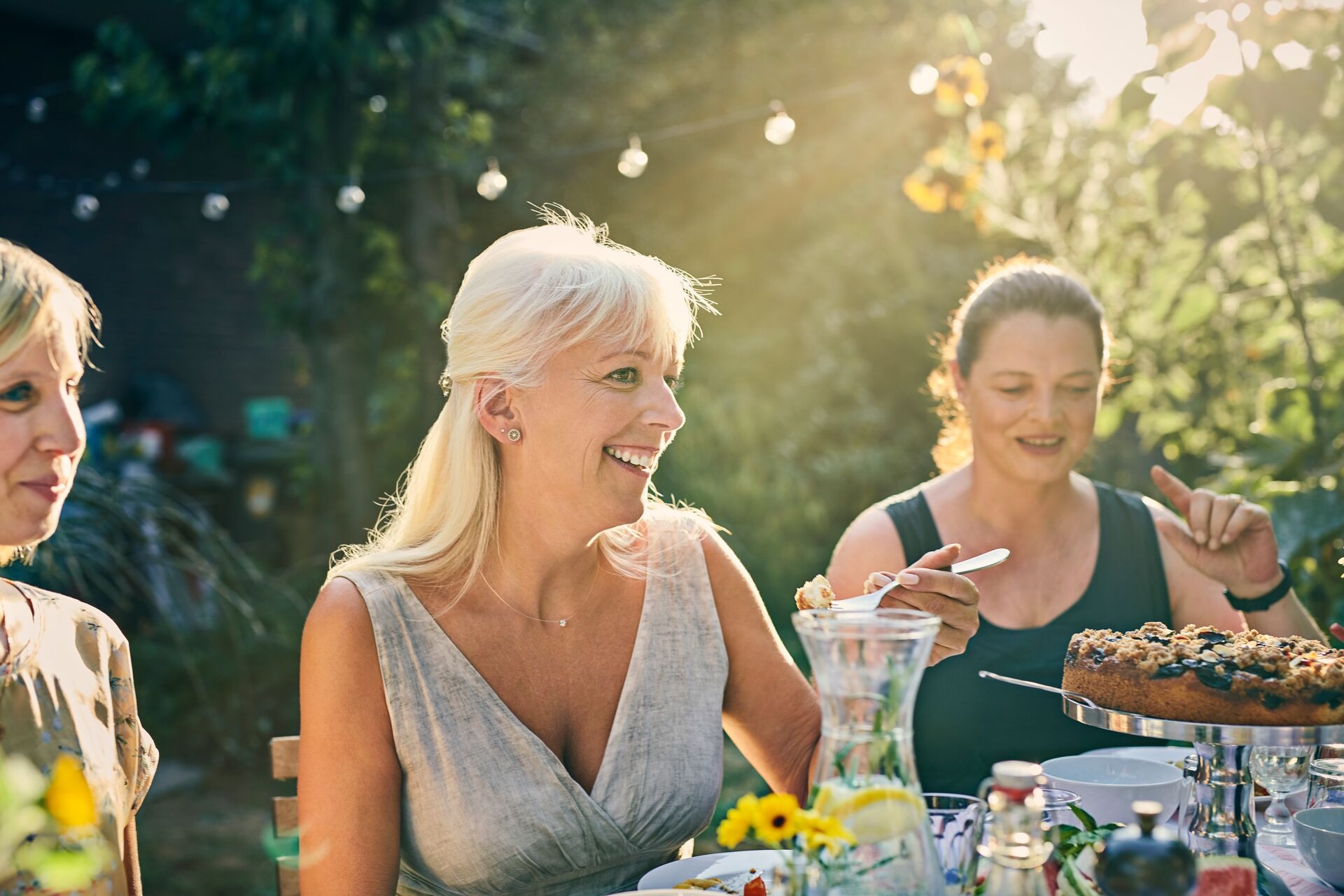 Group of woman eating at dinner party in garden 