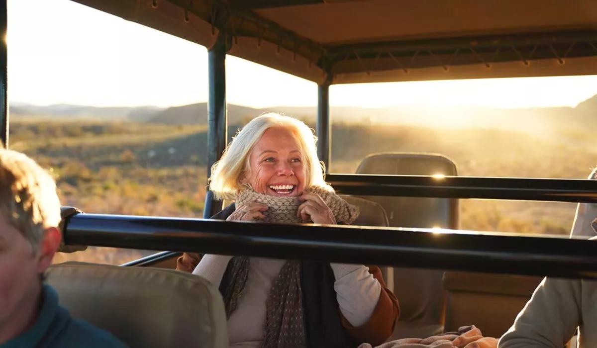 Happy Senior Woman On Safari Riding In Off Road Vehicle