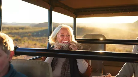 Happy Senior Woman On Safari Riding In Off Road Vehicle