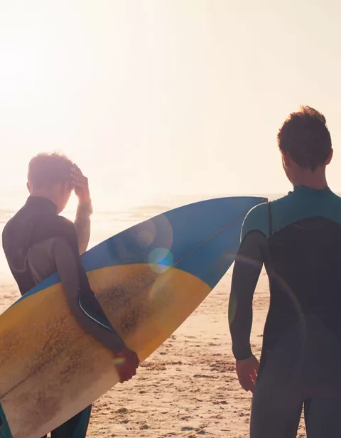 Surfers looking out towards sea