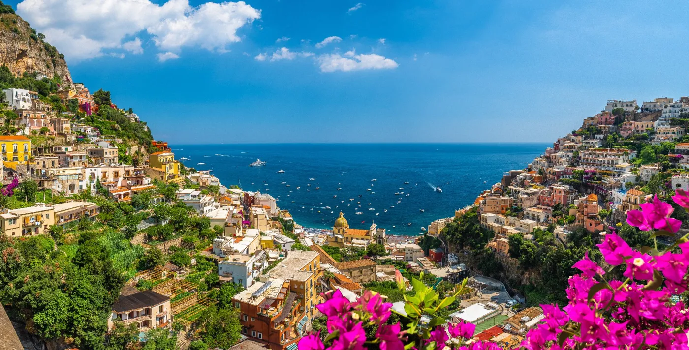The sea, colourful buildings and pink flowers in Positano, Amalfi Coast, Italy