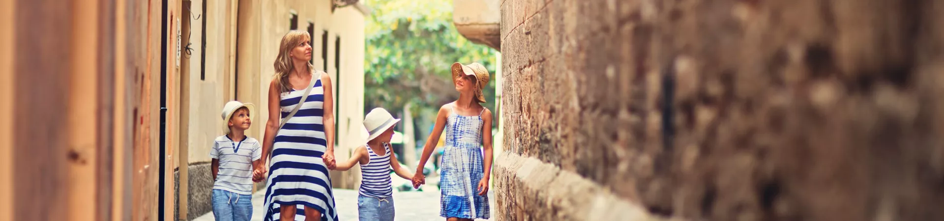 Family walking down a pretty street in Italy while on a family holiday