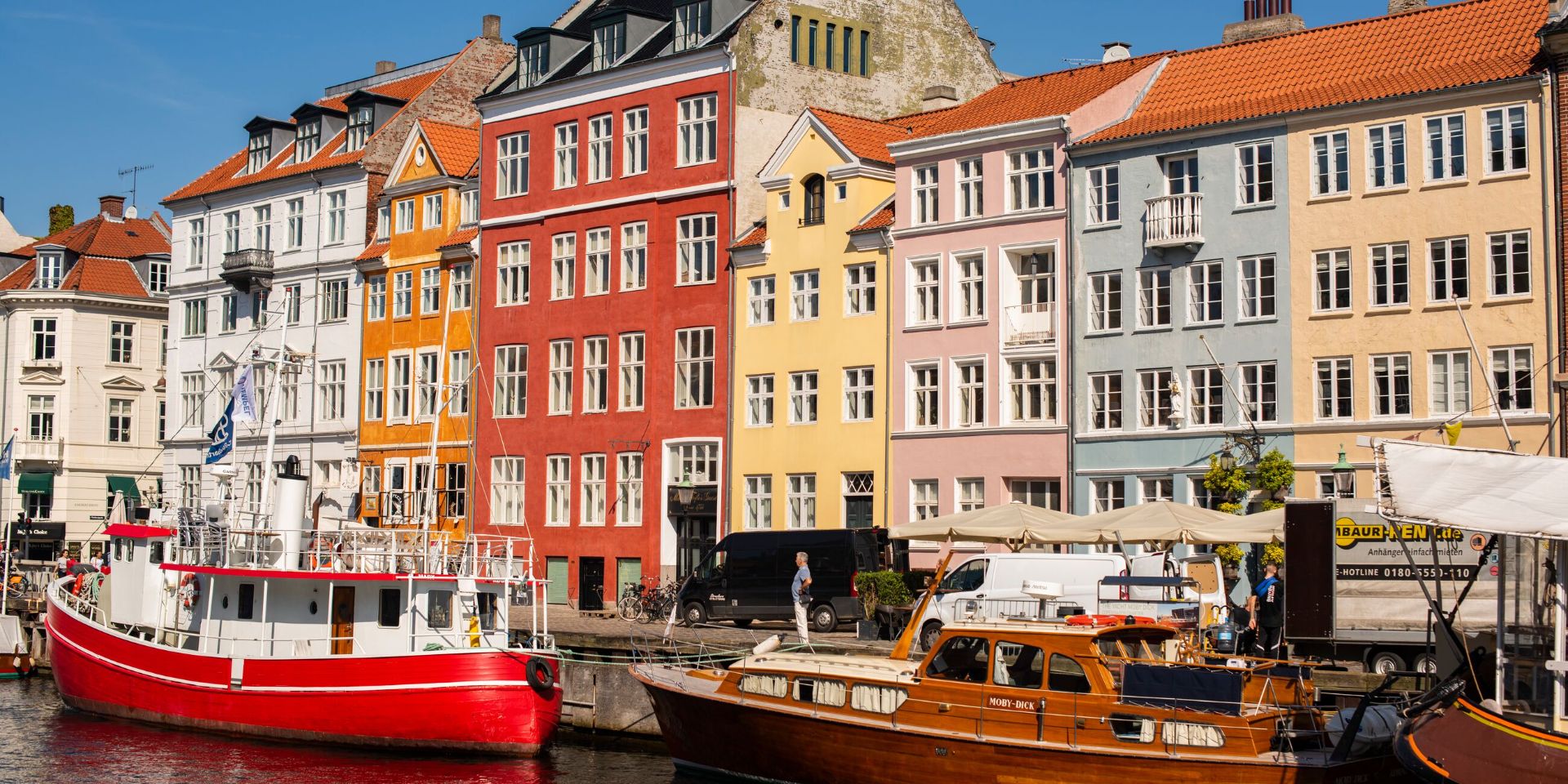 A group of boats next to each other on a river in summer in Copenhagen, Denmark