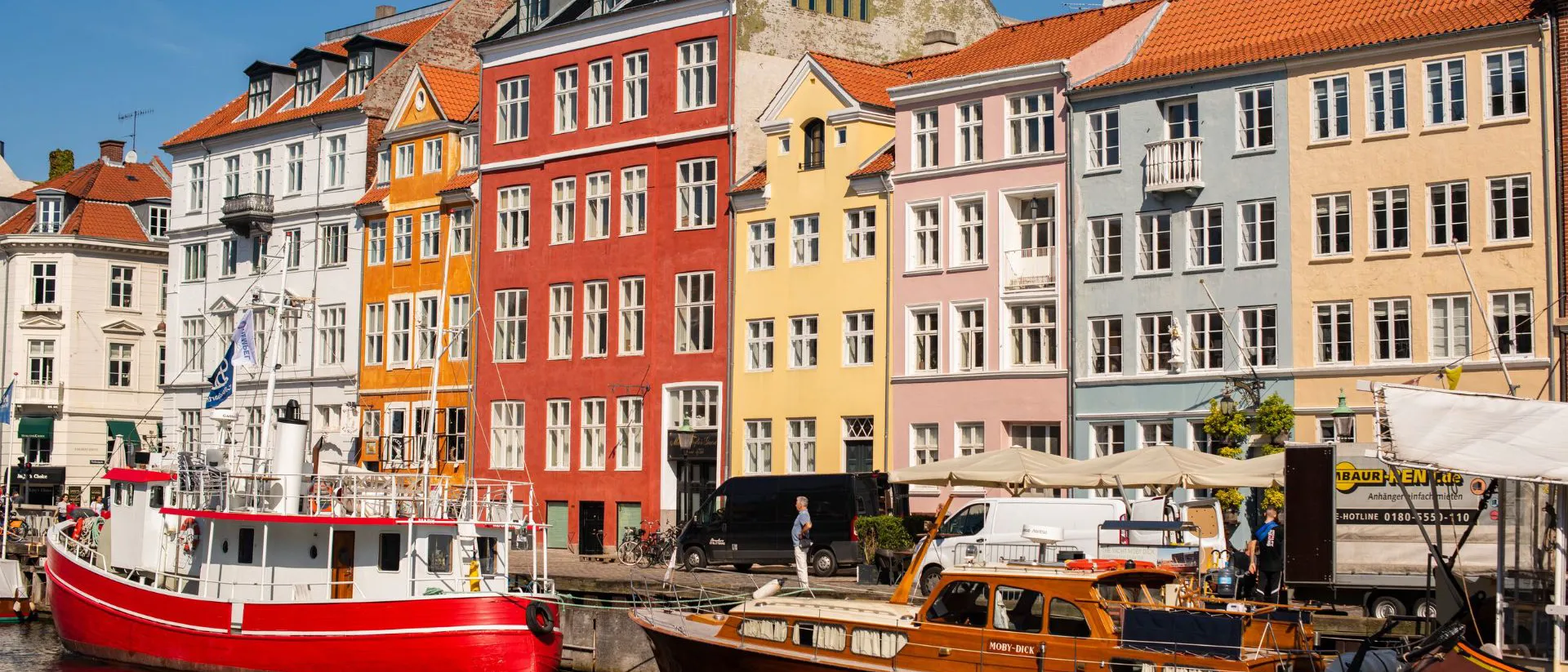 A group of boats next to each other on a river in summer in Copenhagen, Denmark