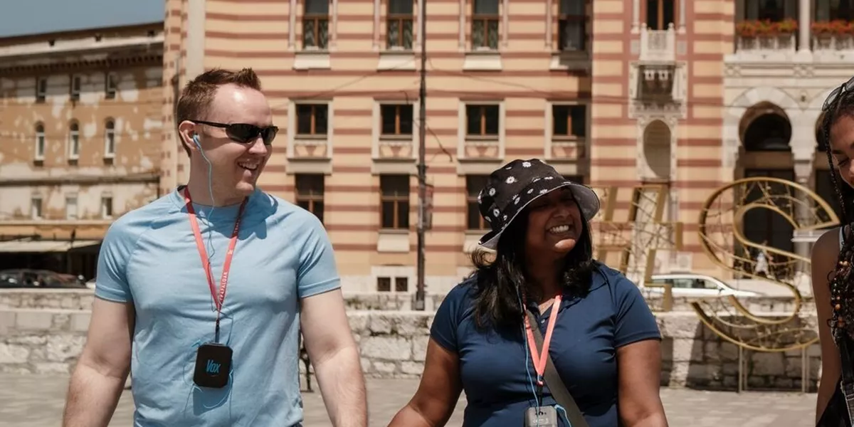 A couple walk hand in hand in front of an elaborate building