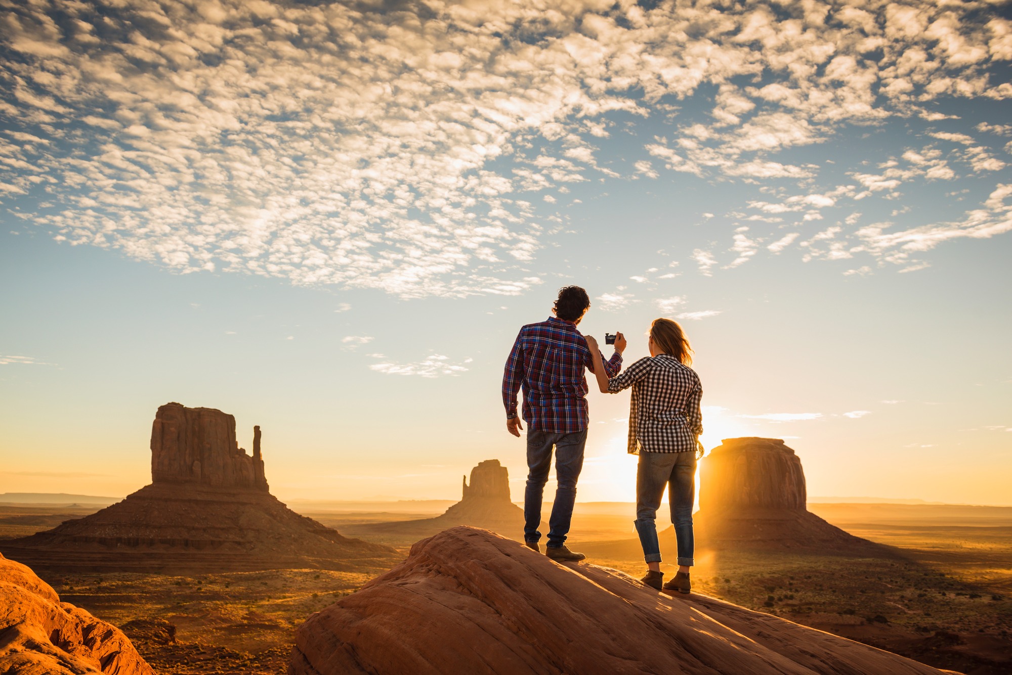 Hispanic couple photographing remote desert 