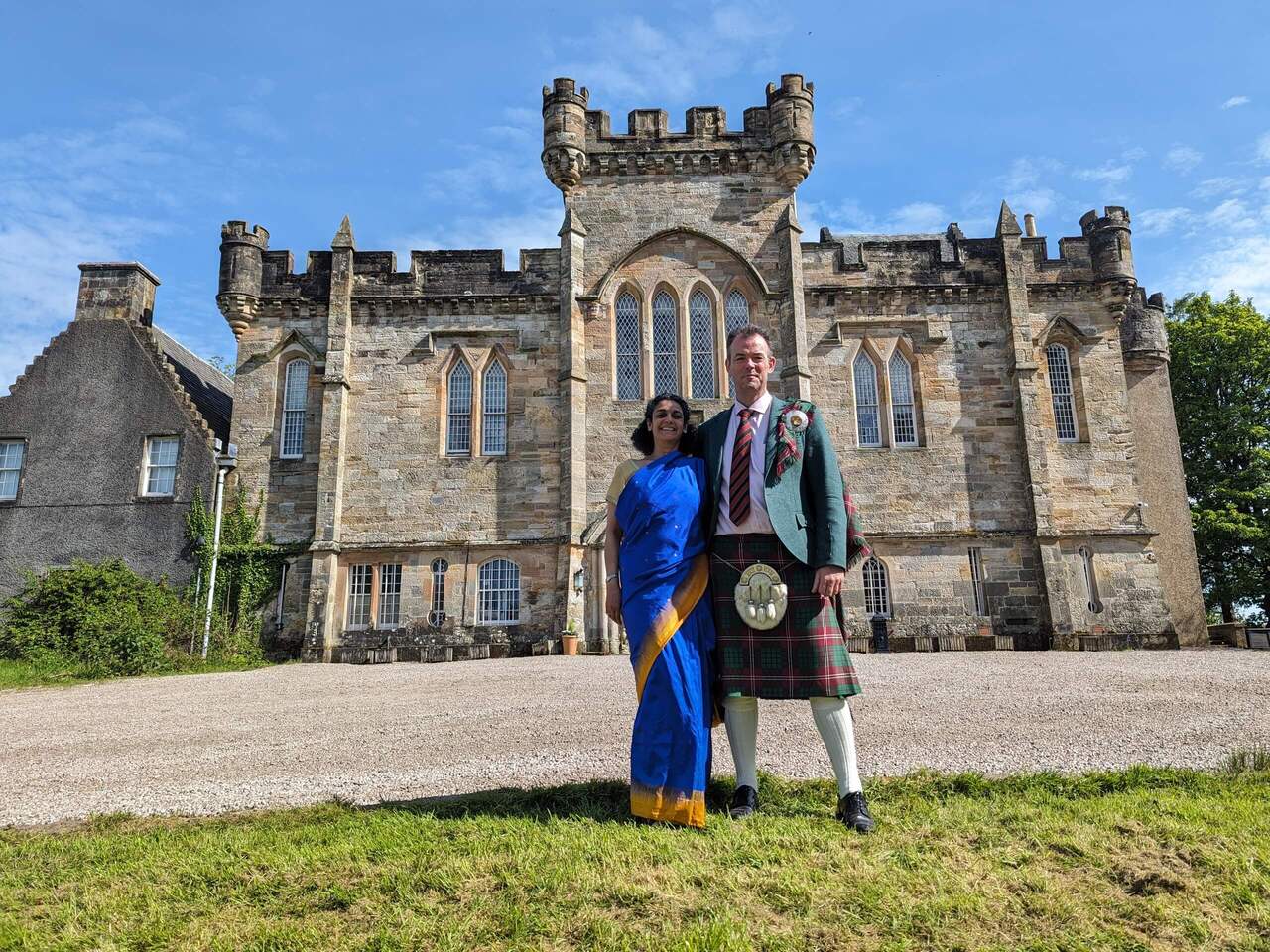 A Man And A Woman In Costumes Standing In Front Of Laird Simon Castle, Scotland