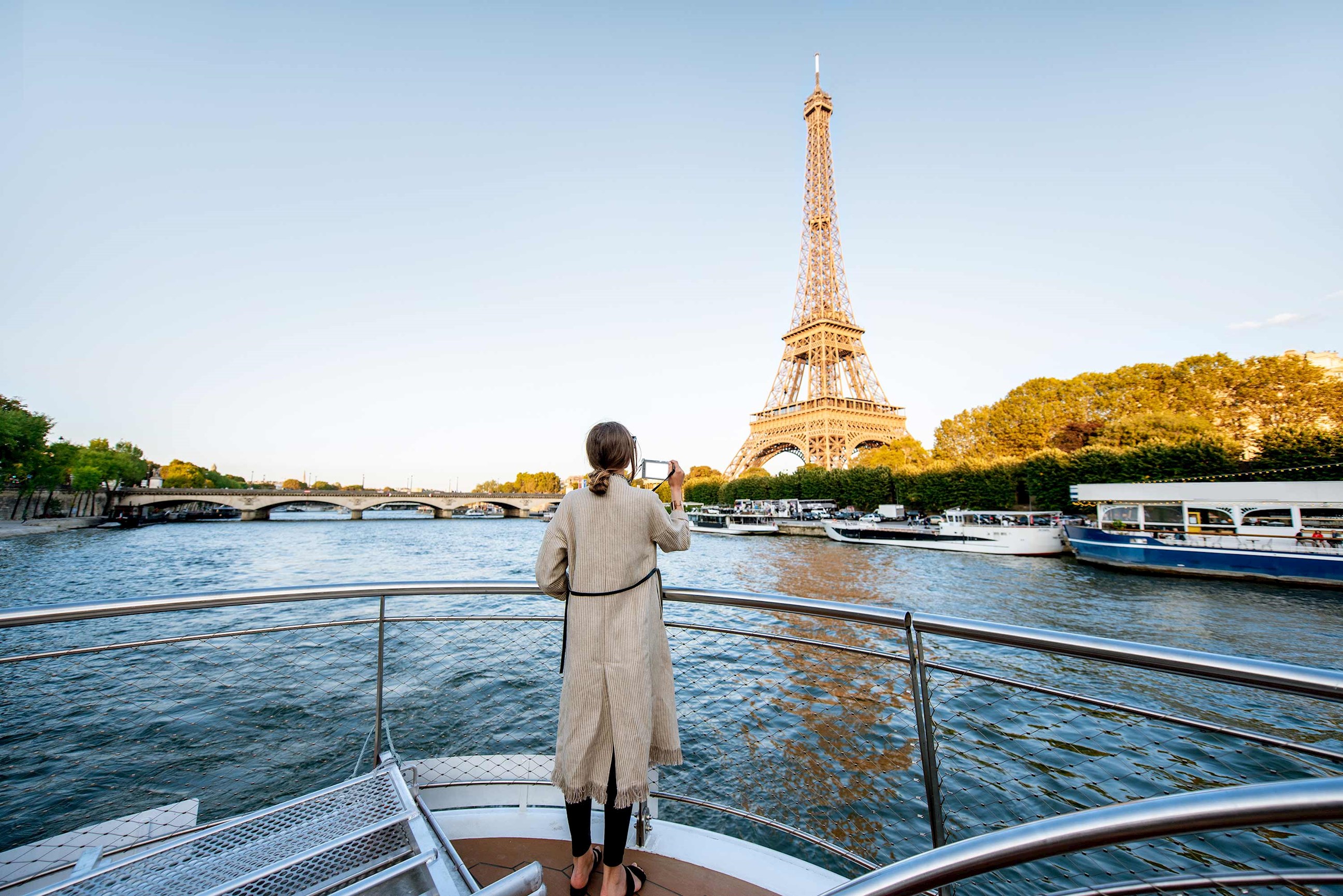 A person on a river cruise taking a photo of the Eiffel Tower