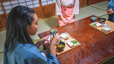 Woman in kimono eating traditional meal in old style Japanese restaurant