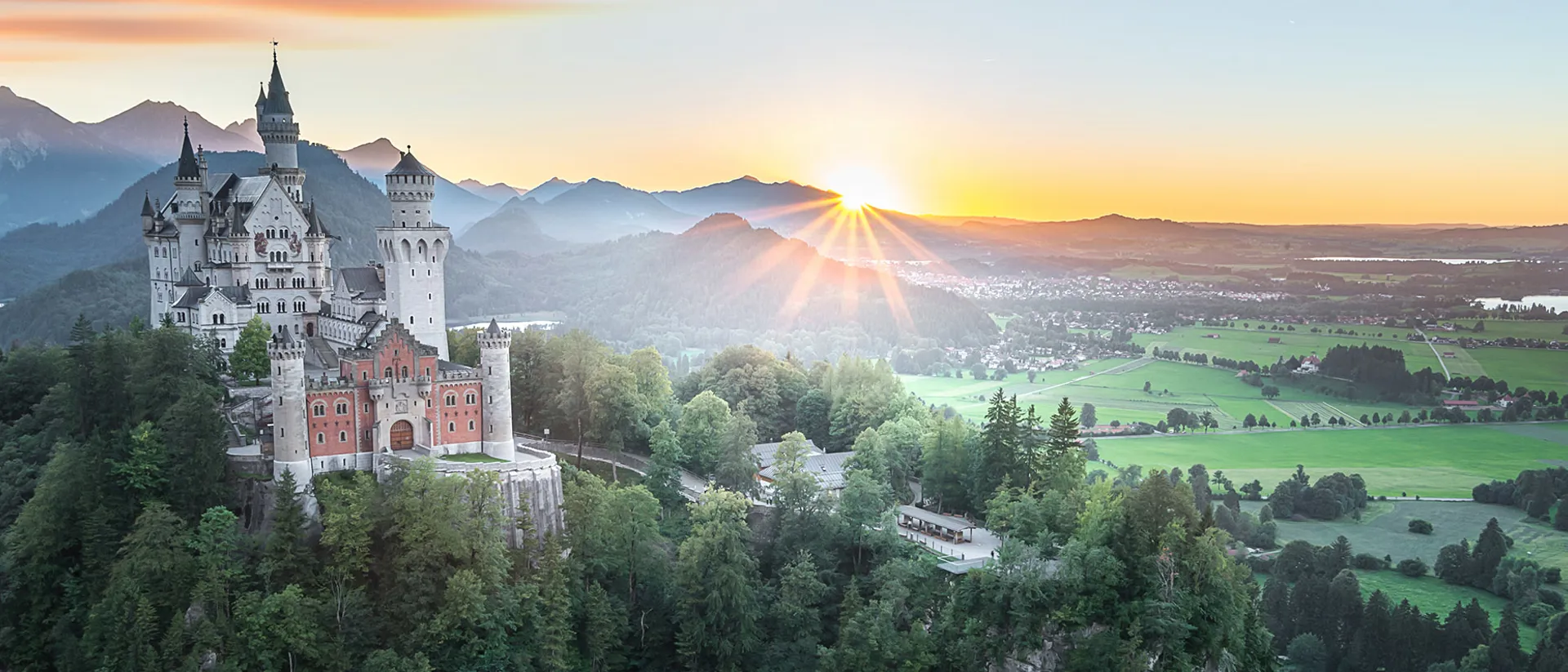 Neuschwanstein Castle on a hill in summer during sunrise in Germany