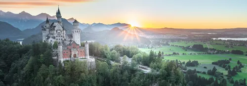 Neuschwanstein Castle on a hill in summer during sunrise in Germany