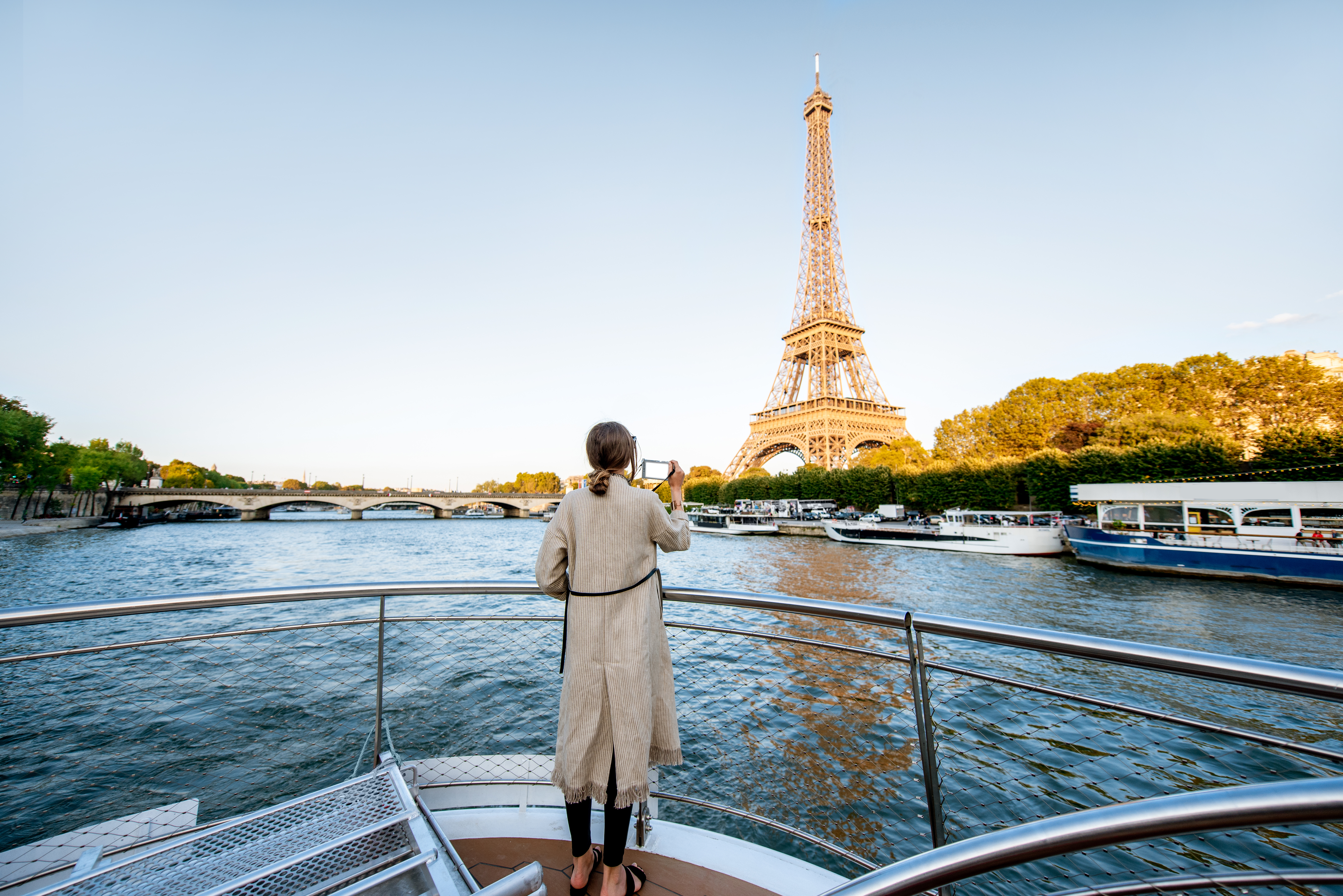 Woman standing on a boat sightseeing the Eiffel Tower in Paris, France