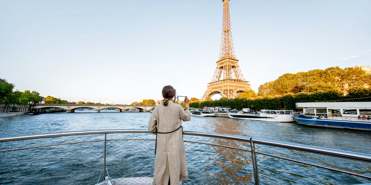 Woman standing on a boat sightseeing the Eiffel Tower in Paris, France