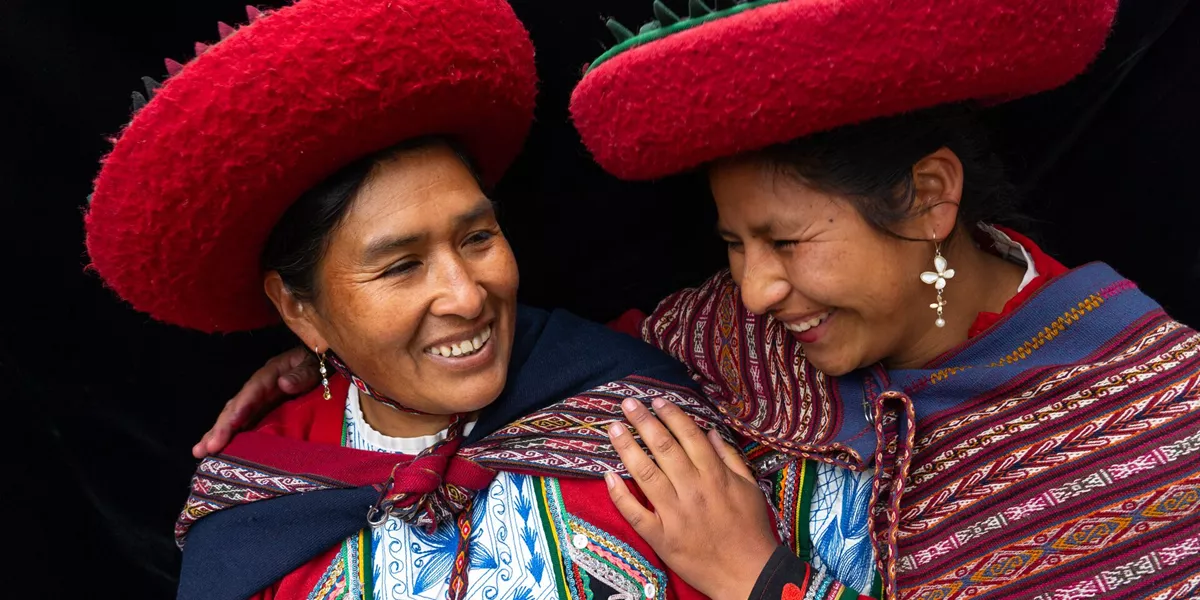 Two Peruvian women smiling in traditional local dress