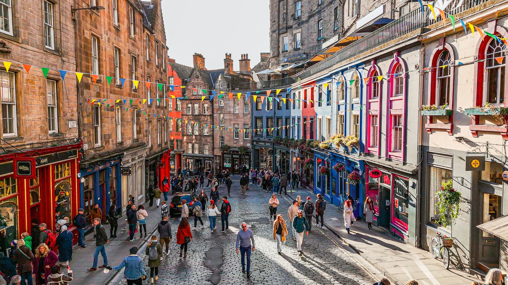 People shopping on Edinburgh's famous Victoria Street on a sunny day in Edinburgh, Scotland