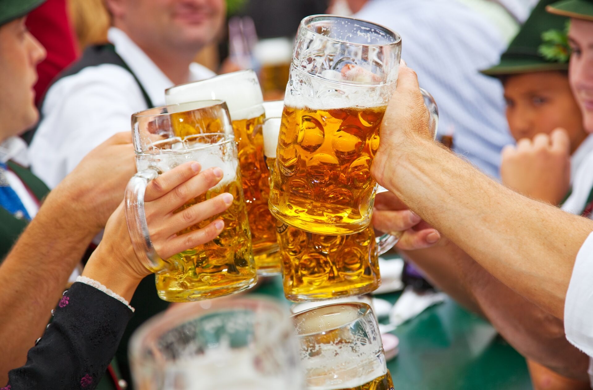 Hands holding beer glasses at Oktoberfest in Munich, Germany