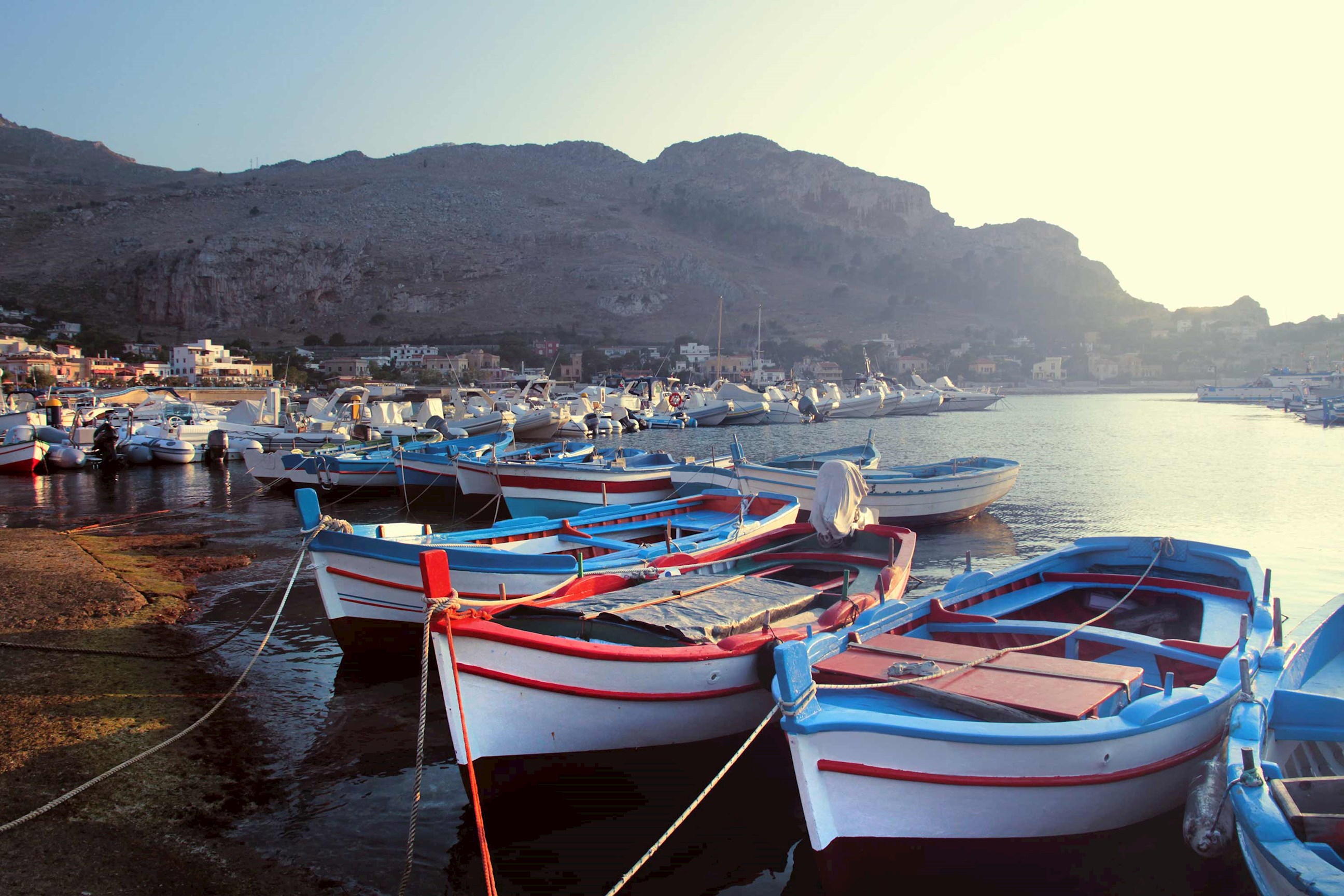 A group of boats docked along the coast of Sferracavallo, Italy