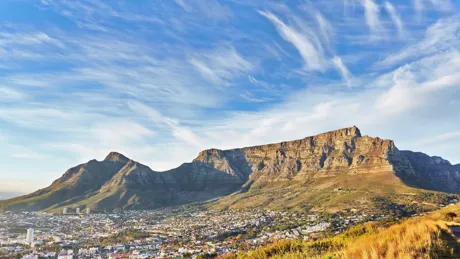 A view of Table Mountain in Cape Town with buildings visible along its base.