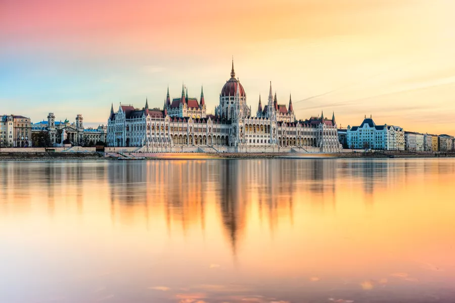 Hungarian Parliament in Budapest, reflected in a beautiful orange-hued river