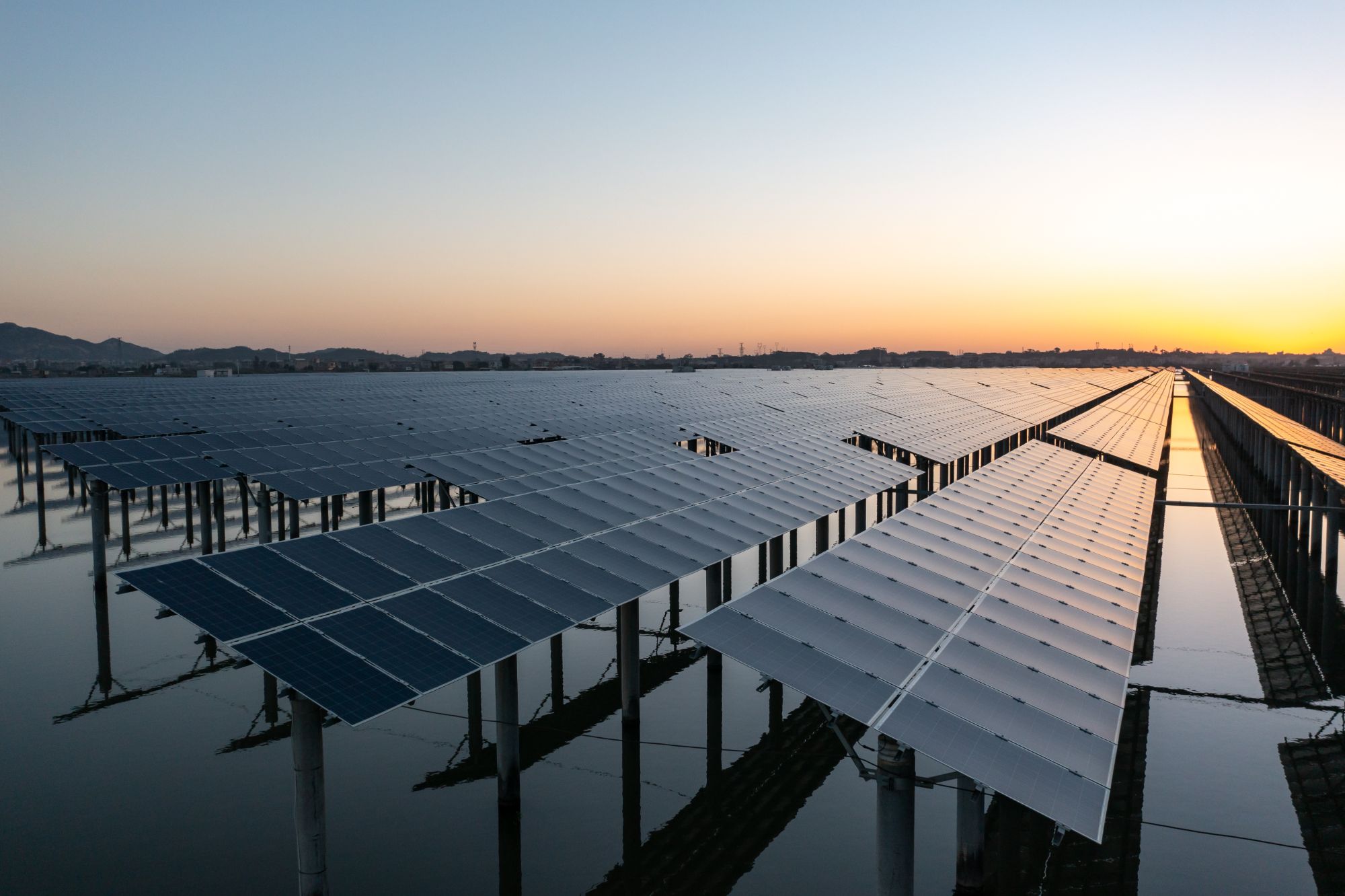 Rows of solar panels of power plant during sunset