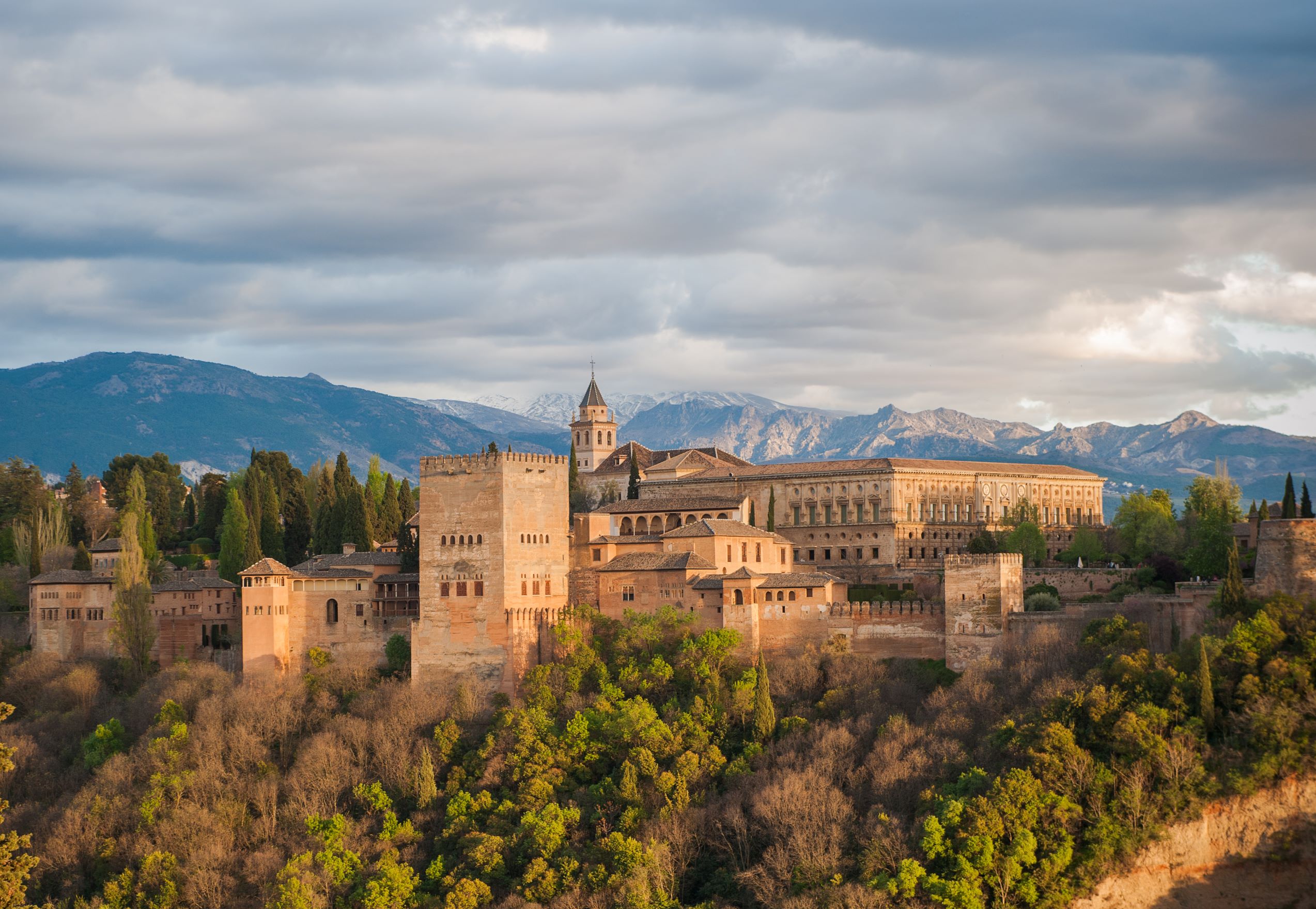 The Alhambra palace in Grenada, Spain. A complex of stone buildings arranged on an imposing plateau.