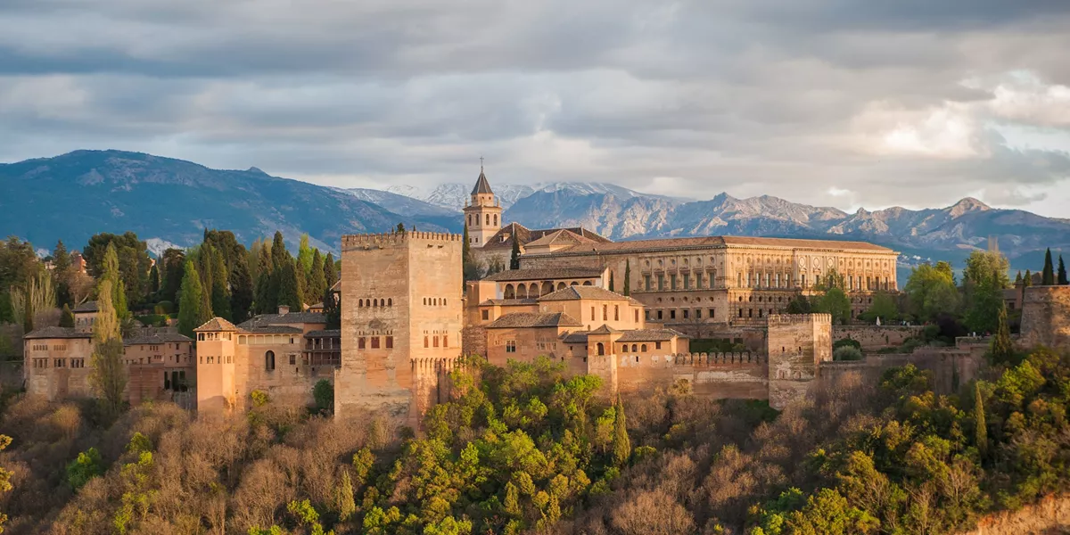 The Alhambra palace in Grenada, Spain. A complex of stone buildings arranged on an imposing plateau.