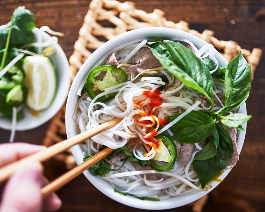 a-person-holding-chopsticks-over-a-bowl-of-food.jpg