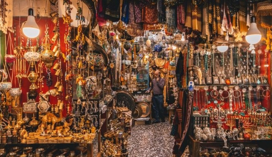 A man standing in a store filled with lots of souvenirs