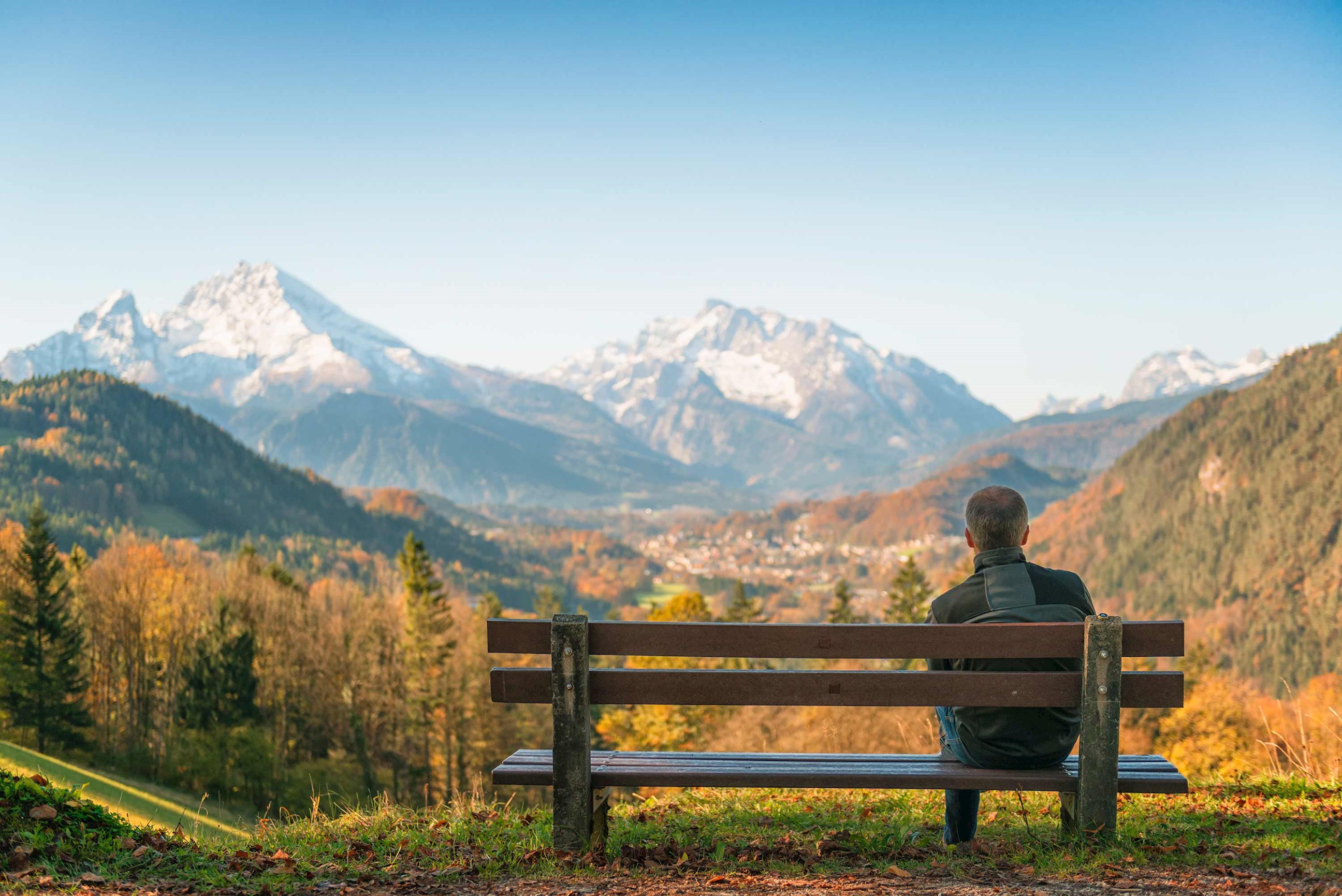 A person sitting alone on a bench looking at Berchtesgaden National Park