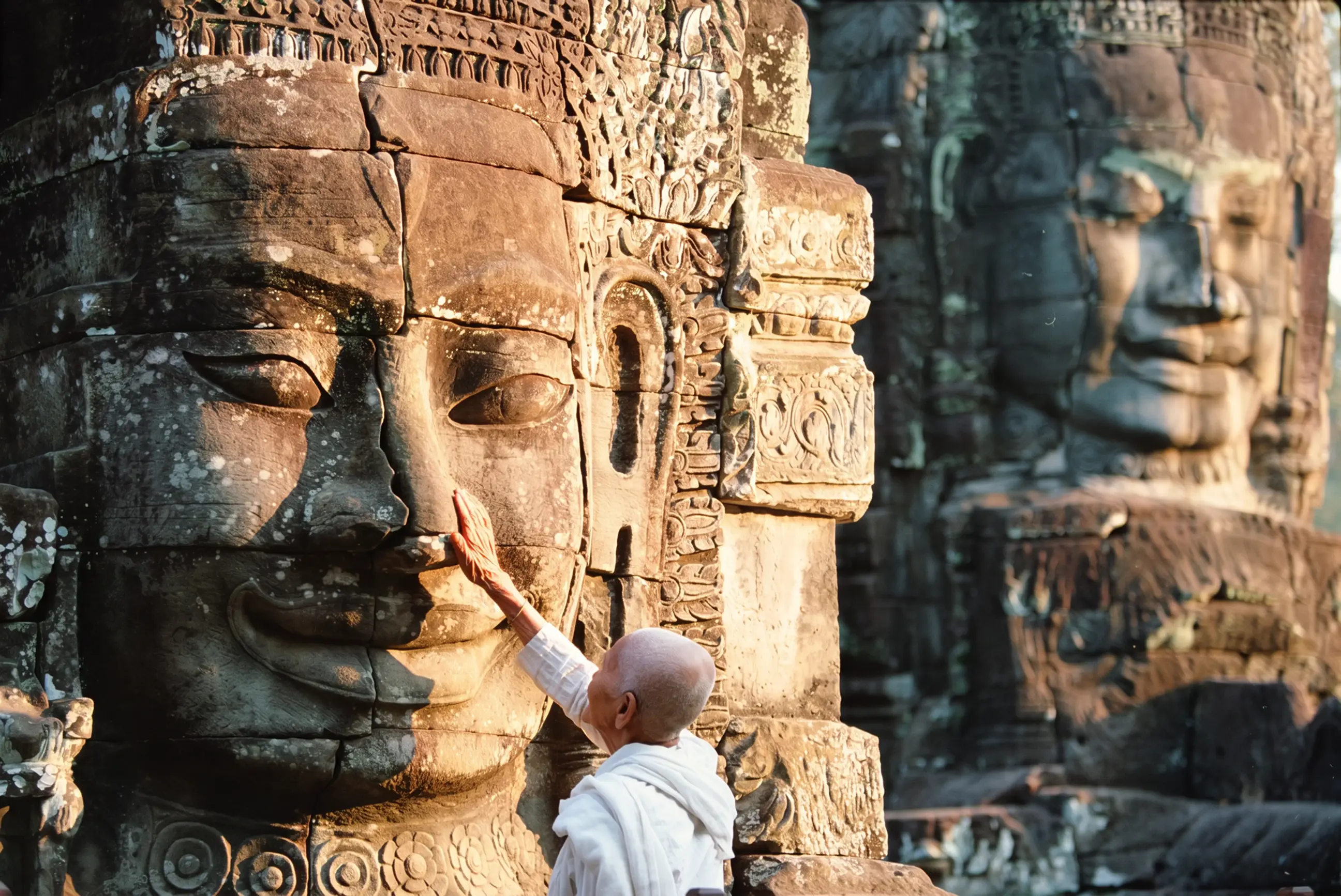 day-hero-buddhist-nun-touching-stone-sculptures-siem-reap-cambodia-200201626-001.webp