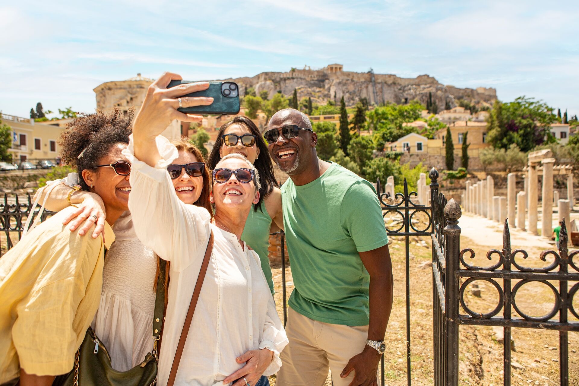 Group of tourists taking selfie in front of ancient ruins in Athens, Greece