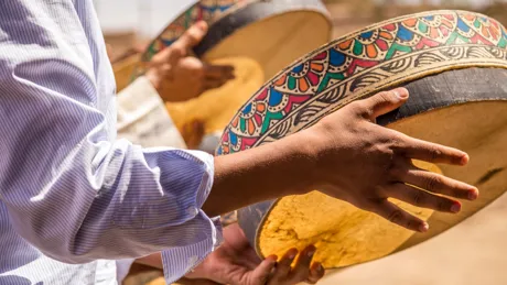 Person playing traditional tambourine on Merzouga Desert in Morocco