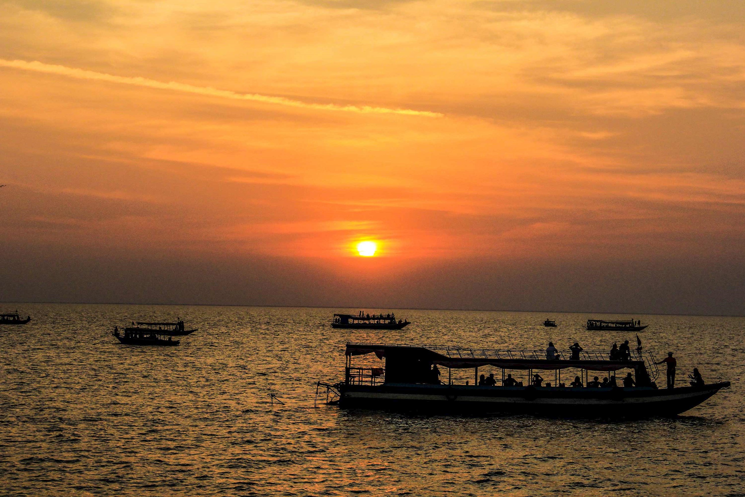 Boat sailing on Tonle Sap Lake during sunset in Cambodia