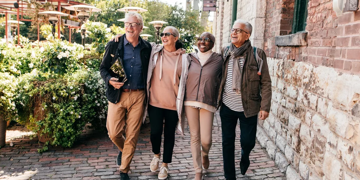 Group of older tourists laughing while walking around a European city