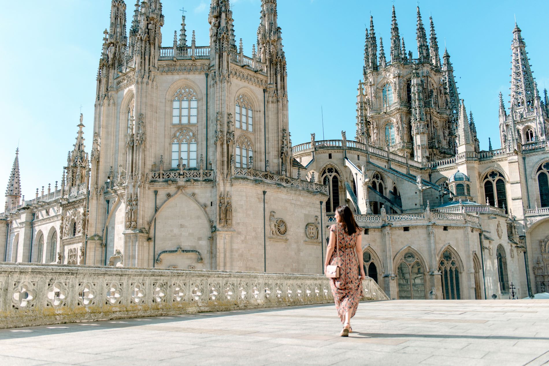 woman-walking-outside-the-cathedral-of-burgos-1169330873.jpg