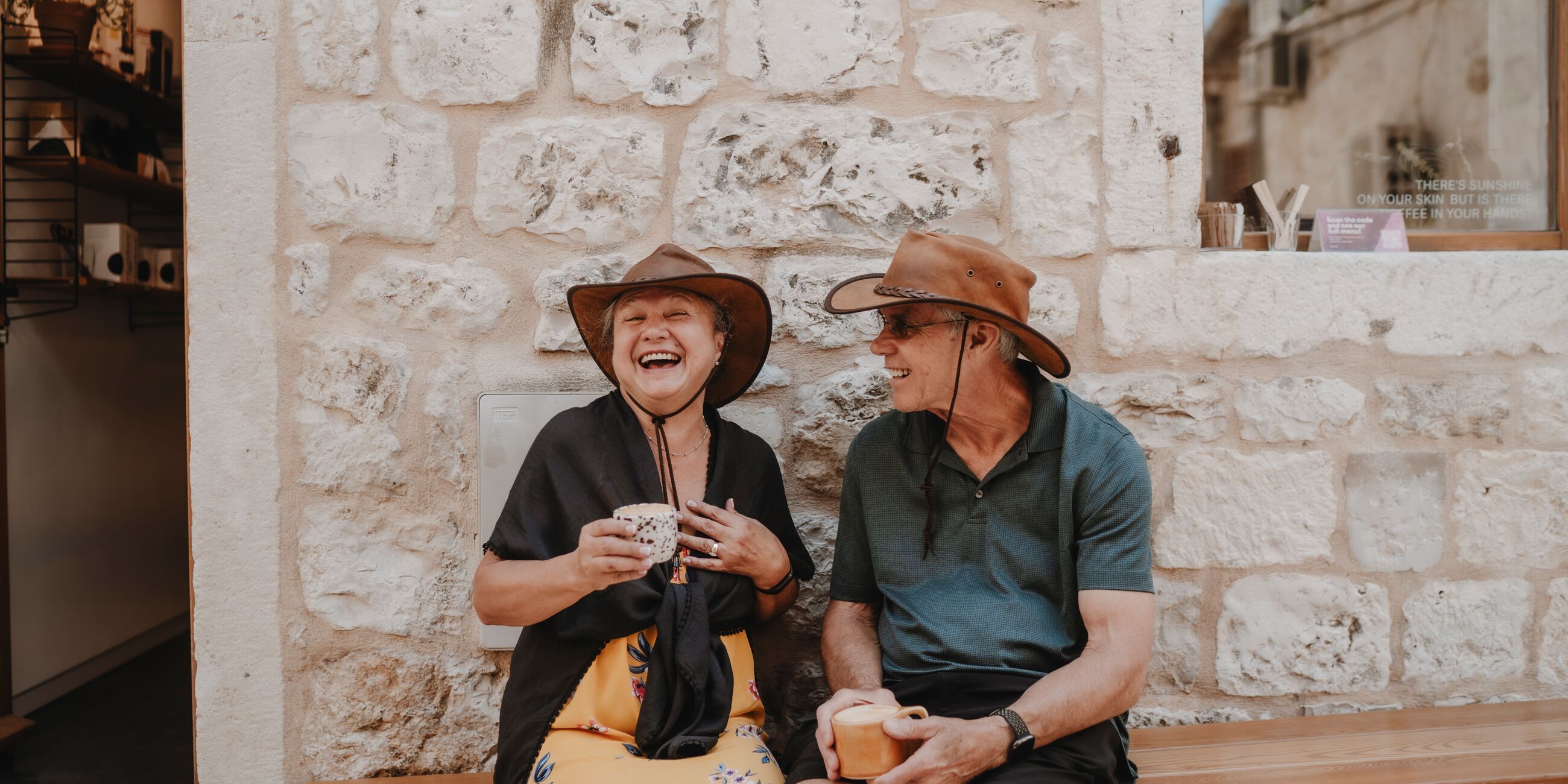 A man and a woman sitting on a bench and laughing
